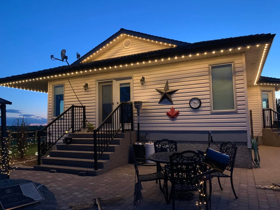 Home eaves outlined in warm Gemstone permanent lights at dusk